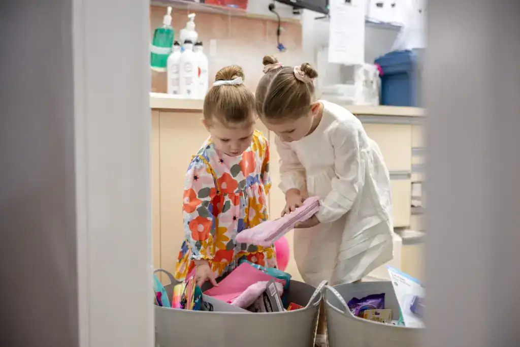 Two children choosing from the practice toy box