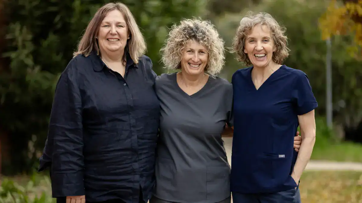 Three members of the practice team laughing together outdoors