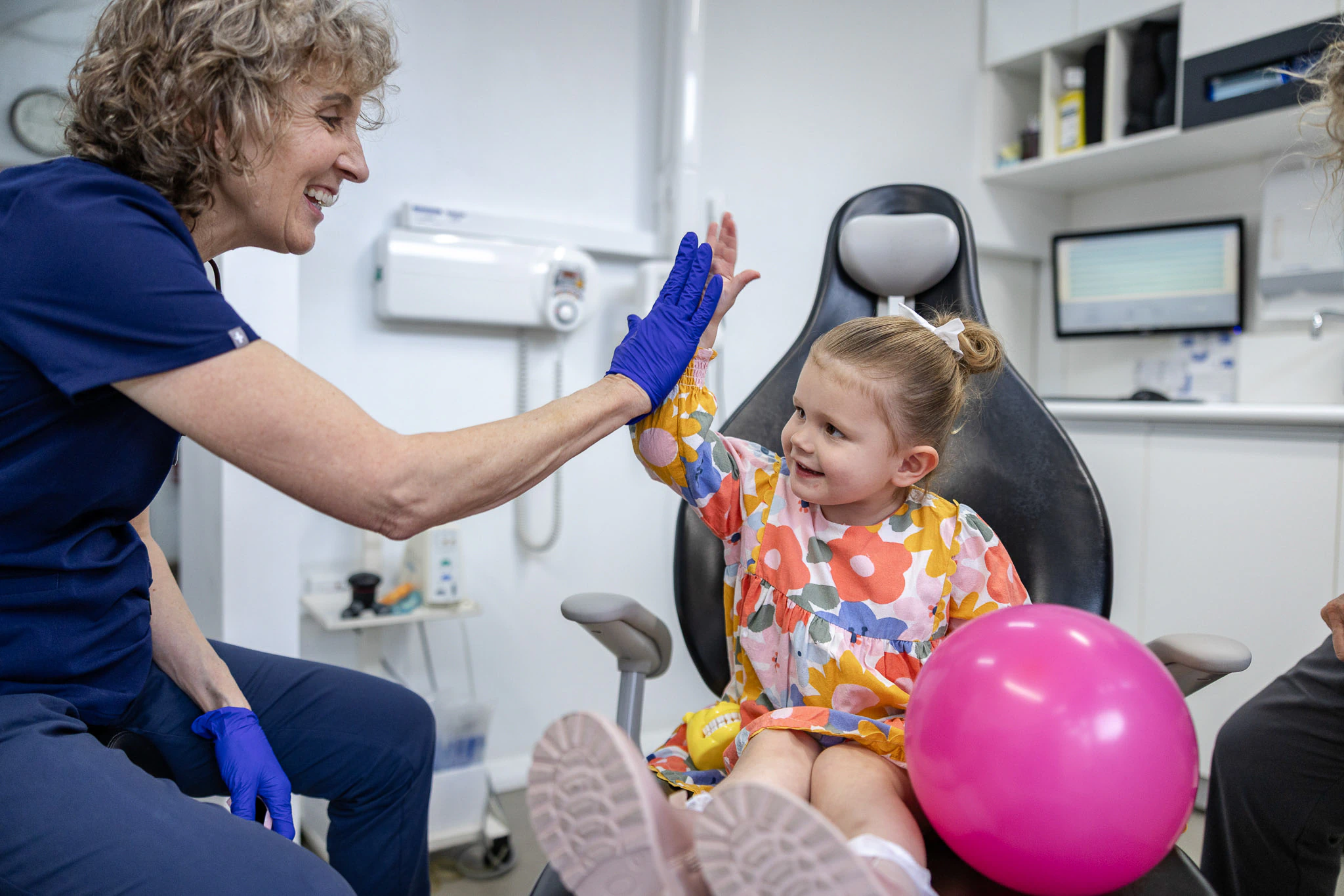Dentist high-fiving a young child in the dental chair