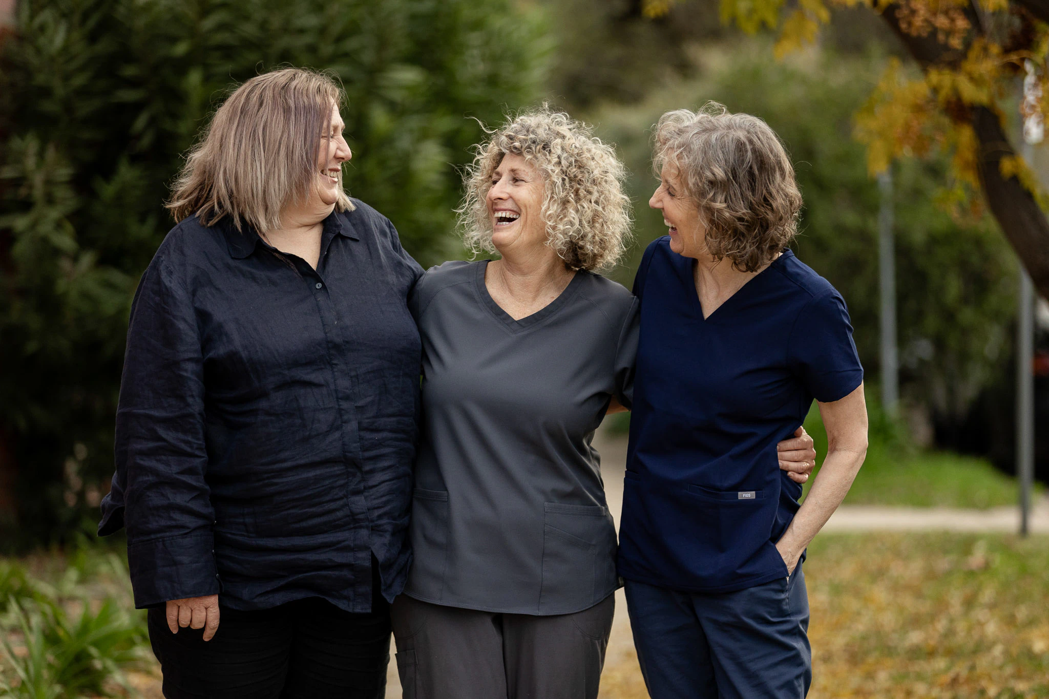 Three members of the practice team laughing together outdoors