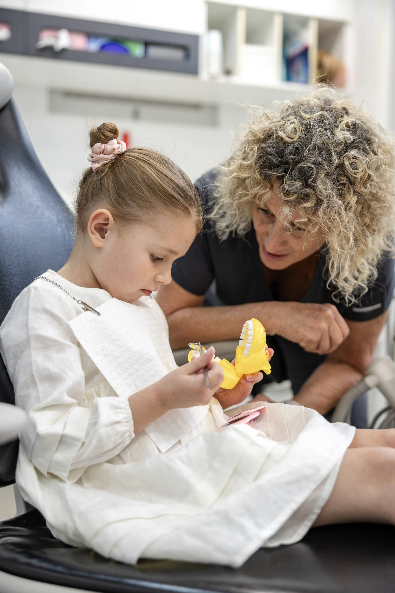Dentist showing a young child a model of teeth